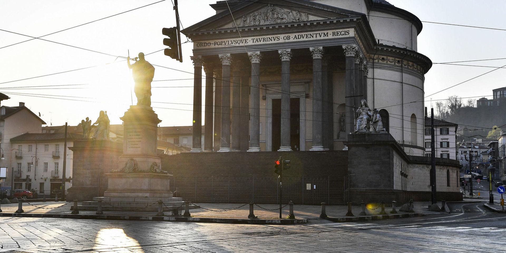 Solen kikar fram bakom kyrkan Gran Madre di Dio i Turin i mars. 