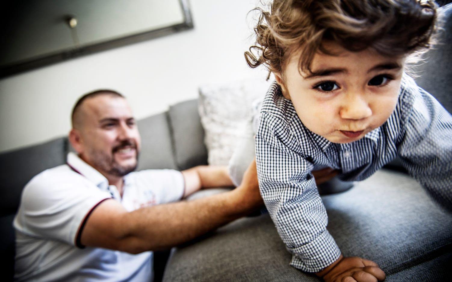 FRAMÅT MED STORMSTEG. Pappa Yusuf håller koll på sonen Eser som klättar på soffan. 16 månader har gått sedan den svåra förlossningen, när Eser fick en nervskada i armen. Bild: Jenny Ingemarsson