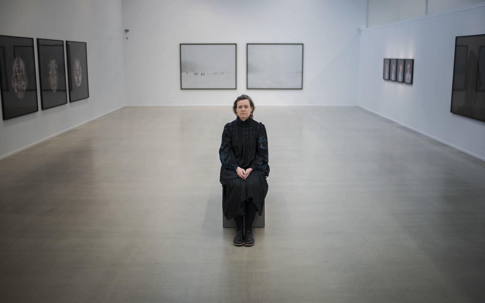 Danska fotografen Trine Søndergaard omringad av några av de 148 verk hon valt ut att visa på sin första stora separatutställning i Sverige, på Göteborgs konstmuseum. 