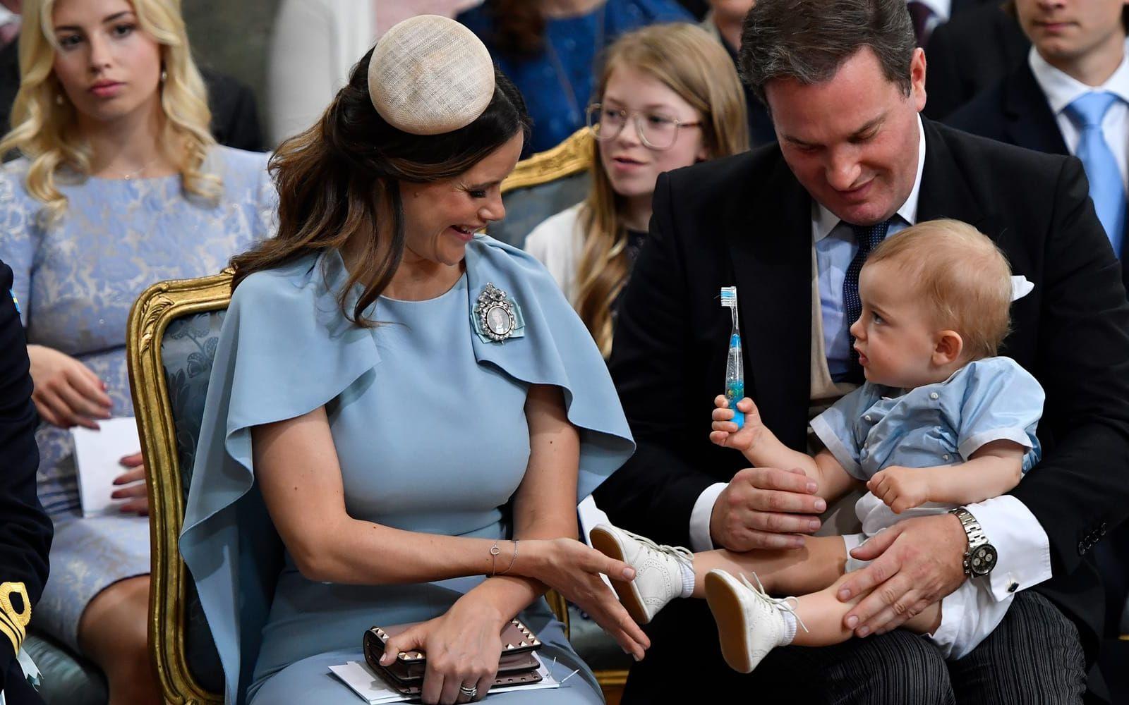 27 maj: Glöm inte tandborsten! Prins Nicolas charmar sin omgivning medan han sitter i pappa Chris O’Neills knä under kusindopet. Foto: TT