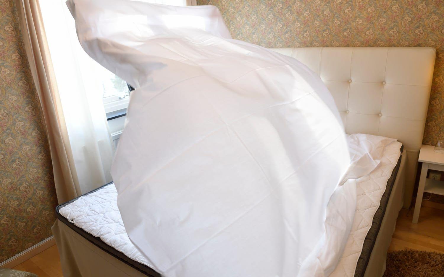 Bäddproffset Agnieszka Gladka skakar ut täcket över sängen. Foto: Henrik Montgomery/TT