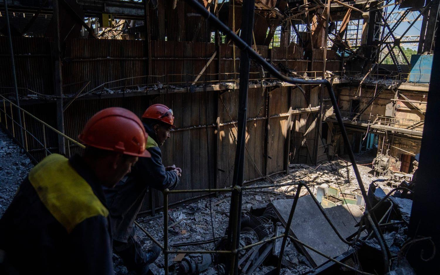 Arbetare står i ett skadat värmekraftverk i Ukraina efter en rysk attack i maj 2024.