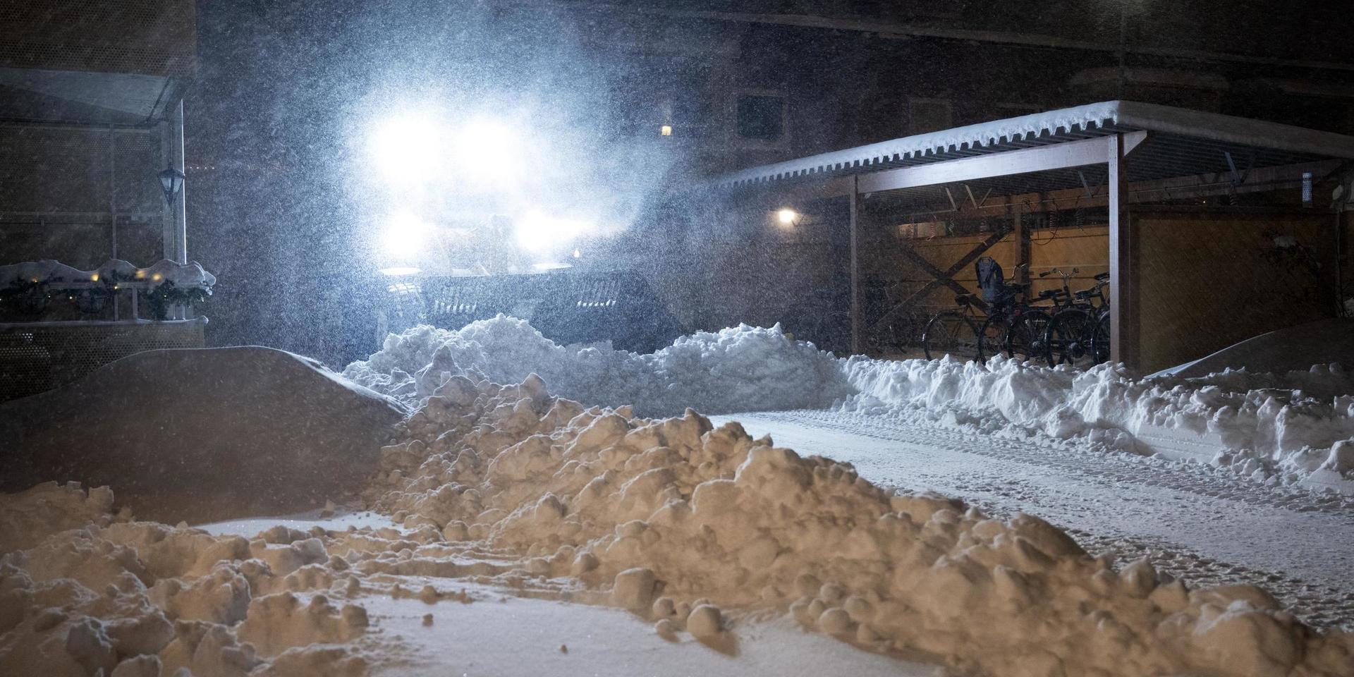 En traktor plogar bland några hus i snöovädret i Umeå, på tisdagsmorgonen den 12 januari.
