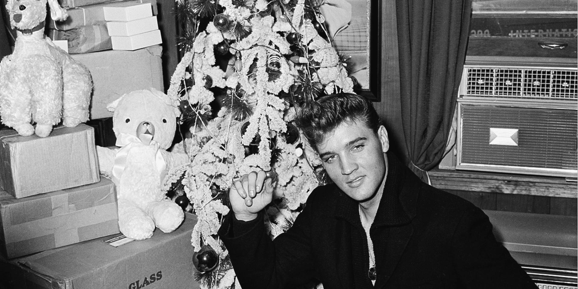 Elvis Presley poserar framför sin julgran i Memphis 1960. 
