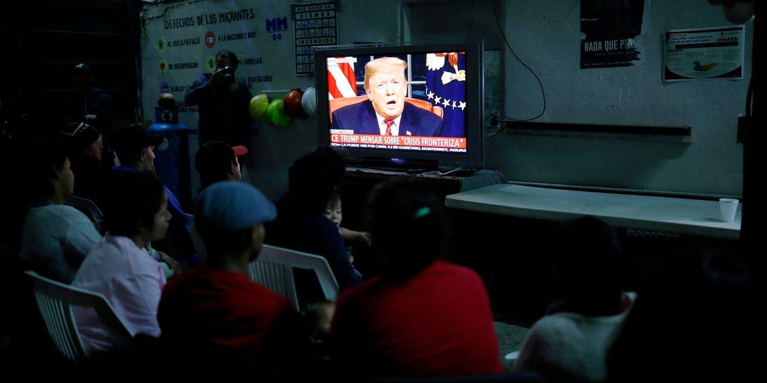Migranter från Mexiko och Centralamerika tittar på Trumps tv-tal i ett migrantcenter i gränsstaden Tijuana, Mexiko.