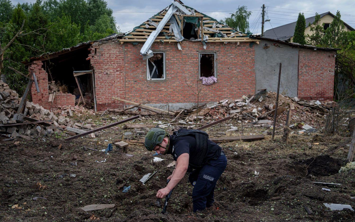 En ukrainsk polis på platsen för ett bombnedslag i Charkiv på lördagen.