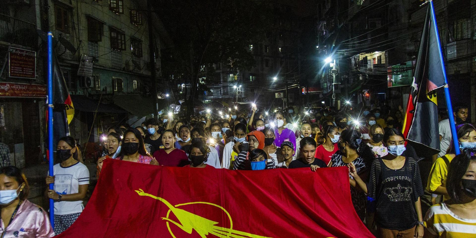 Demonstranter i storstaden Rangoon på måndagskvällen.