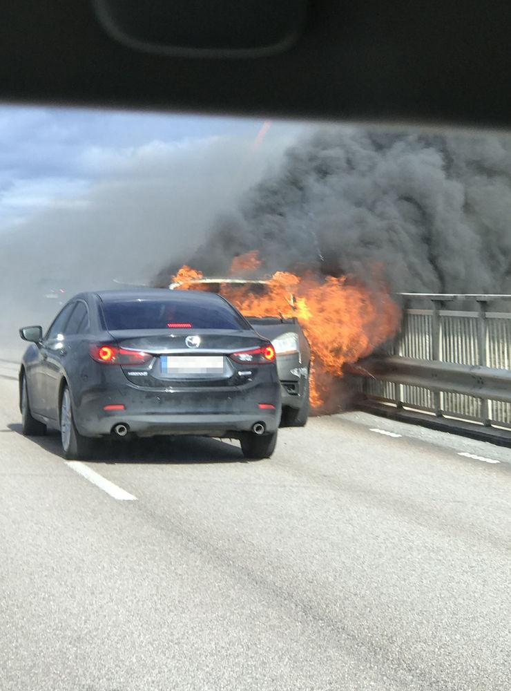 En personbil har börjat brinna under färd på Tjörnbron.