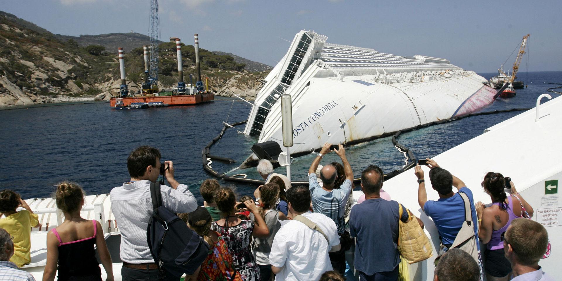 Turister tar bilder på vraket av Costa Concordia vid den italienska ön Giglio 2012.