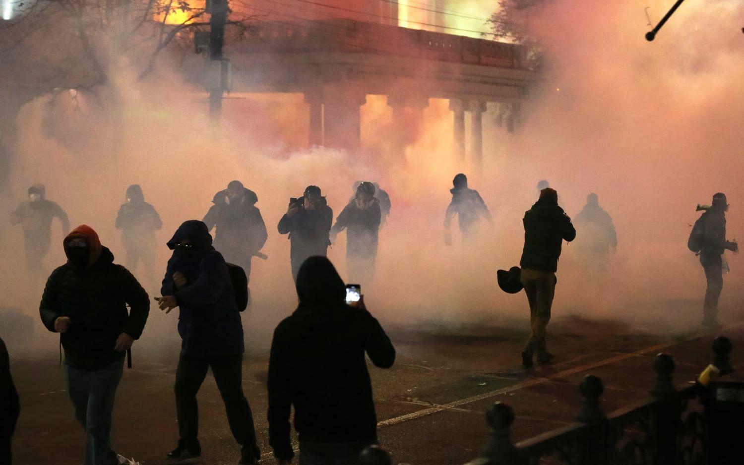 Demonstranter rör sig genom ett moln av tårgas i centrala Tbilisi under natten mot tisdagen.