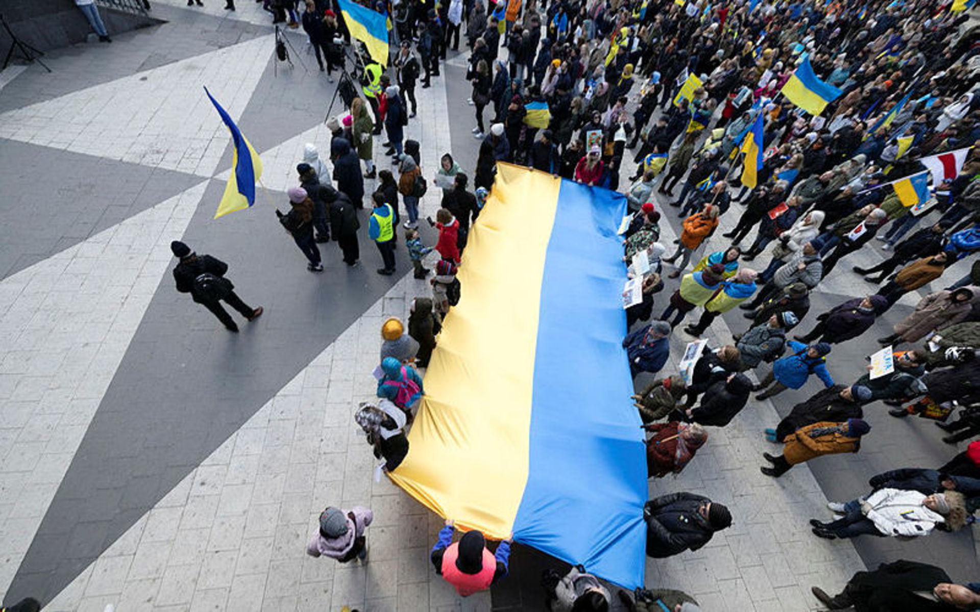 Flera av människorna på plats samlades kring en ukrainsk flagga som de höll upp tillsammans.