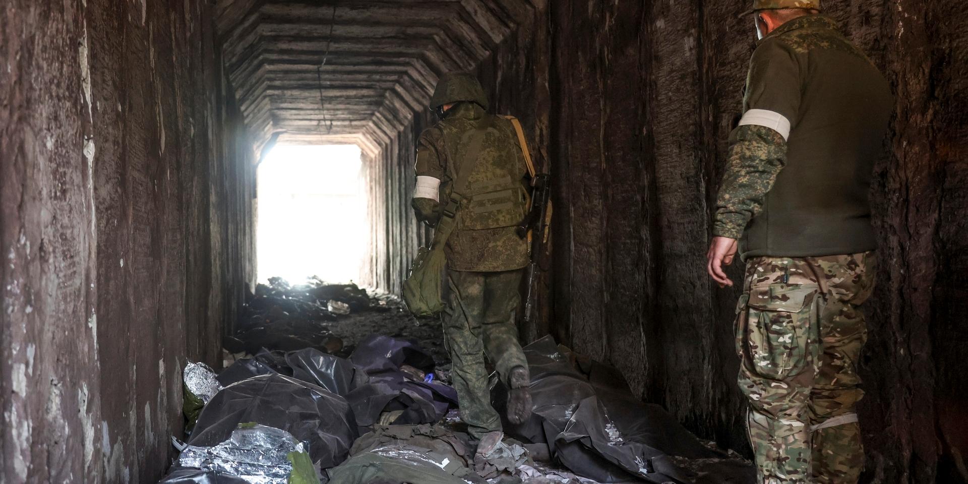 Milissoldater från Donetsk bland döda ukrainska soldater som placerats i plastsäckar i en tunnel vid den metallurgiska anläggningen i Mariupol, i ett område under kontroll av de ryskstödda separatisterna.