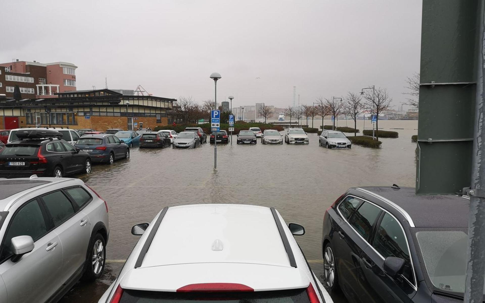 En parkering har fyllts med vatten från den översvämmade älven.

