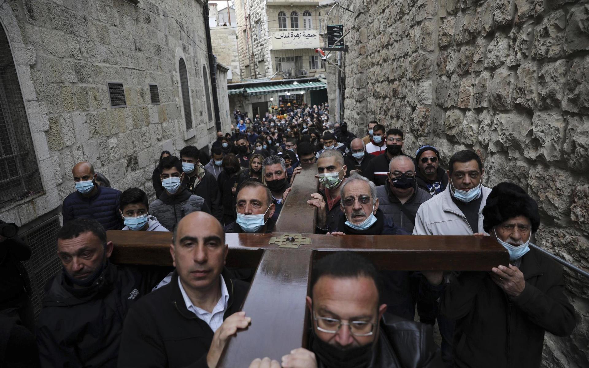 Kristna bär ett kors längs Via Dolorosa i Jerusalem. 