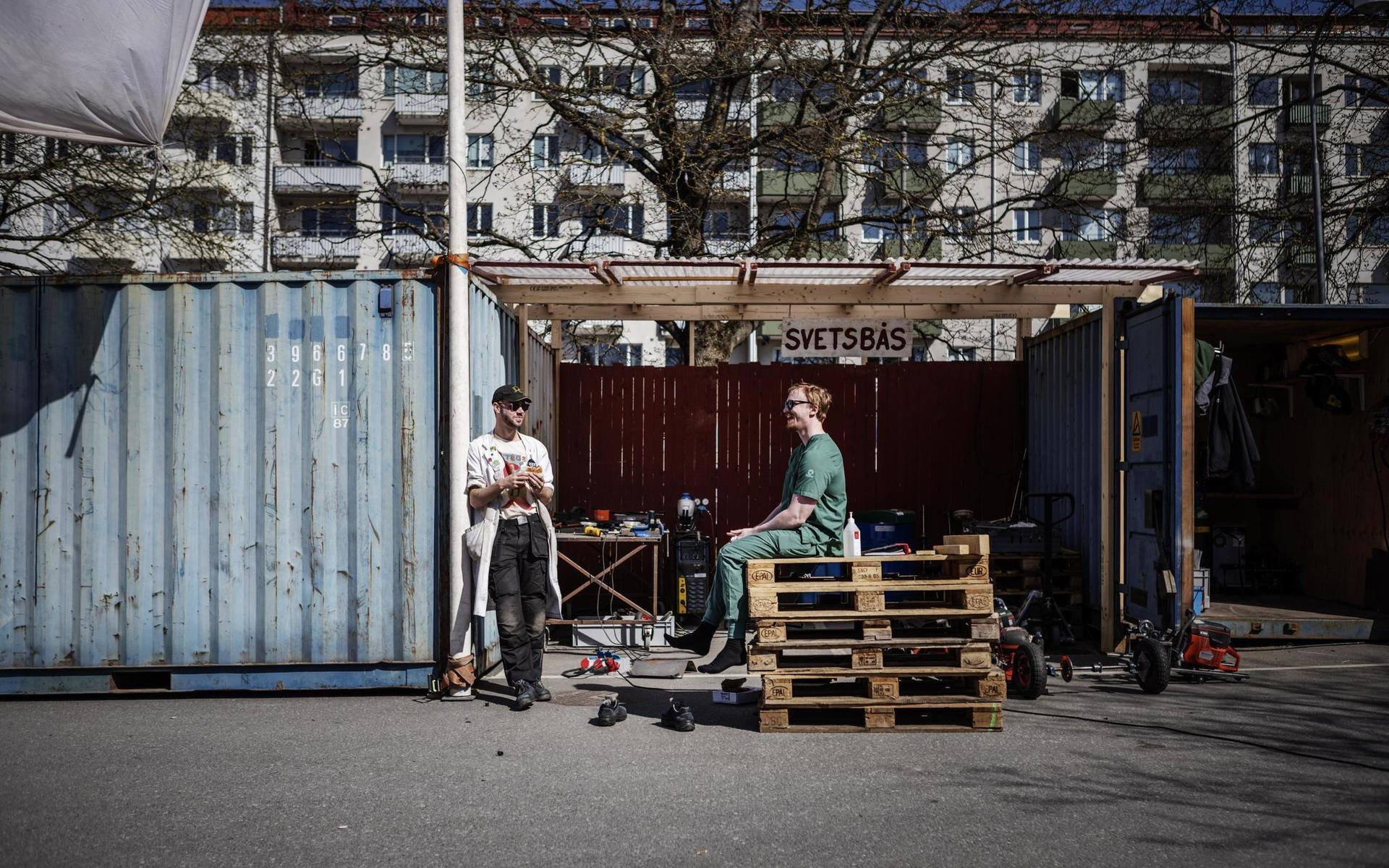 Erik Laitala och Martin Almqvist käkar hamburgerlunch vid svetsbåset. För att bygglagen inte ska komma samtidigt måste de boka tid.