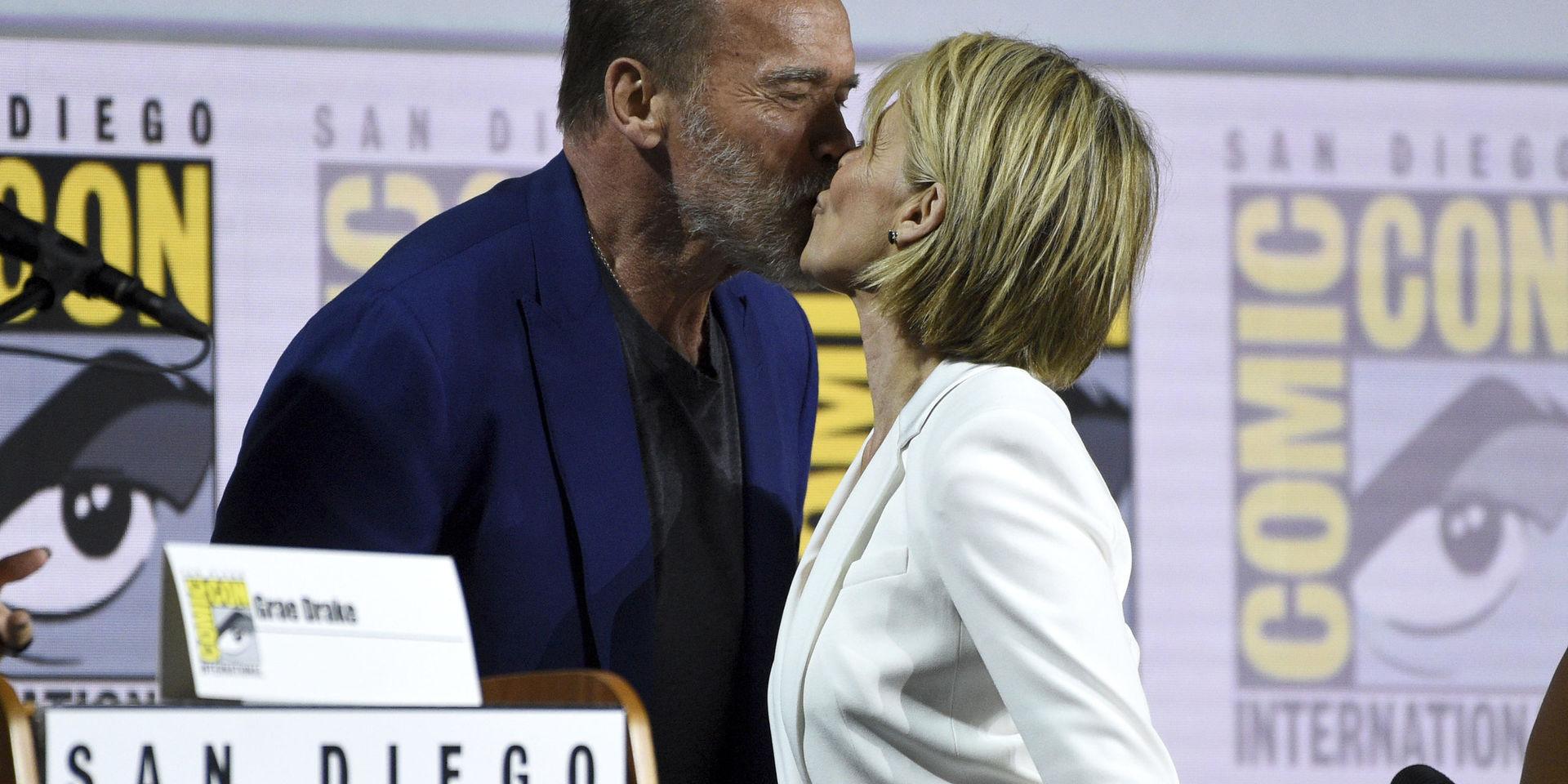Arnold Schwarzenegger och Linda Hamilton pussar varandra i samband med ett panelsamtal vid Comic-Con-mässan.