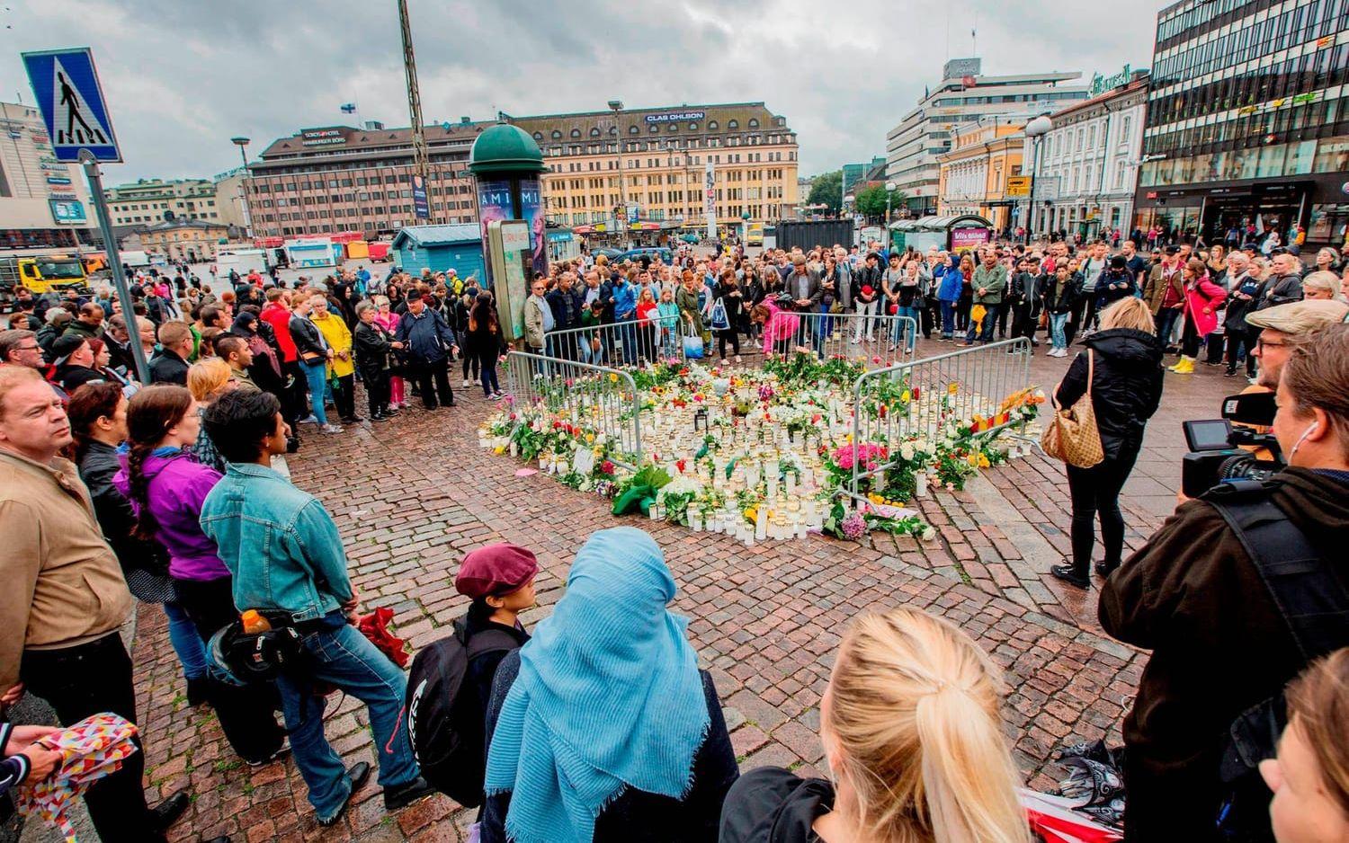Många lämnade blommor och tände ljus på den avspärrade platsen på Salutorget i Åbo där flera personer knivhöggs i en terrorattack under fredagseftermiddagen. Bild: TT