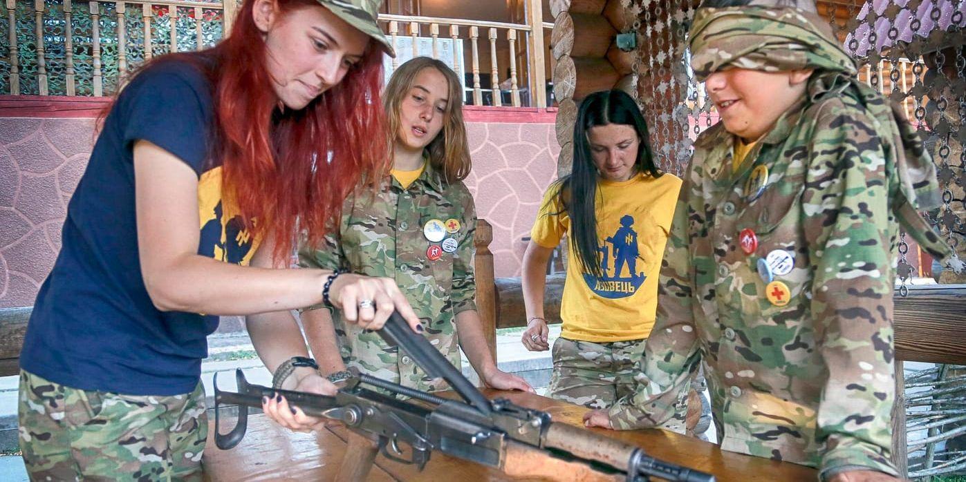 Barn i det krigshärjade Ukraina får en lektion i vapenhantering på ett sommarläger utanför Kiev.