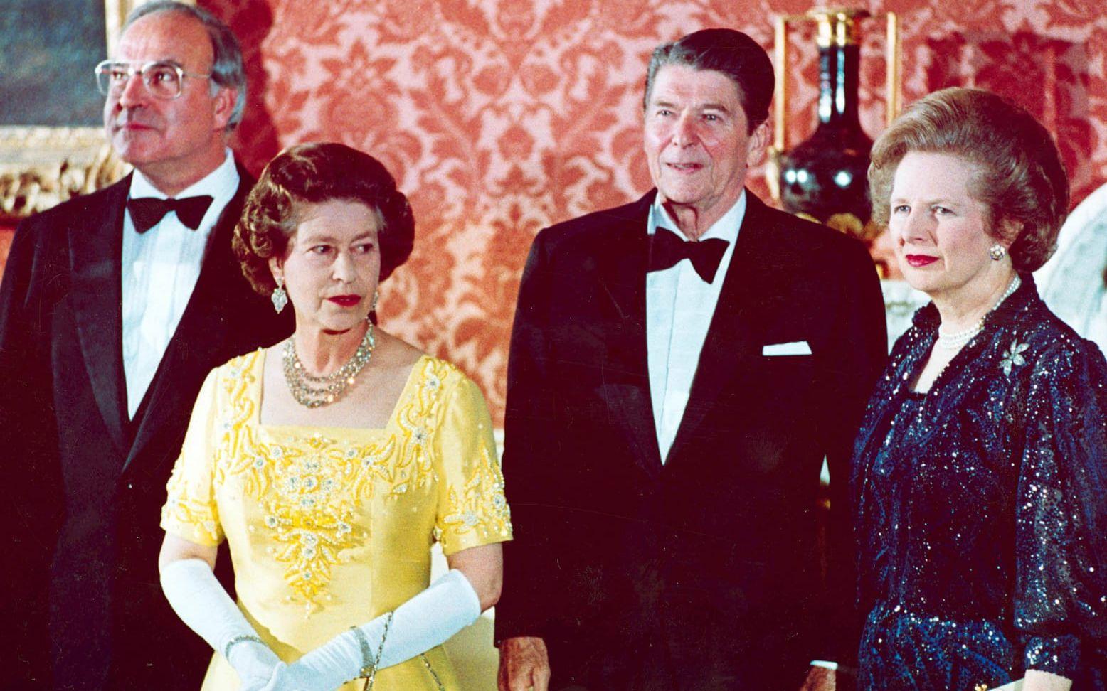 Thatcher var drottningens åttonde premiärminister i raden. Här fotas de 10 juni 1984 tillsammans med Västtyskland förbundskansler Helmut Kohl, USA:s president Ronald Reagan, strax innan en middag på Buckingham Palace.