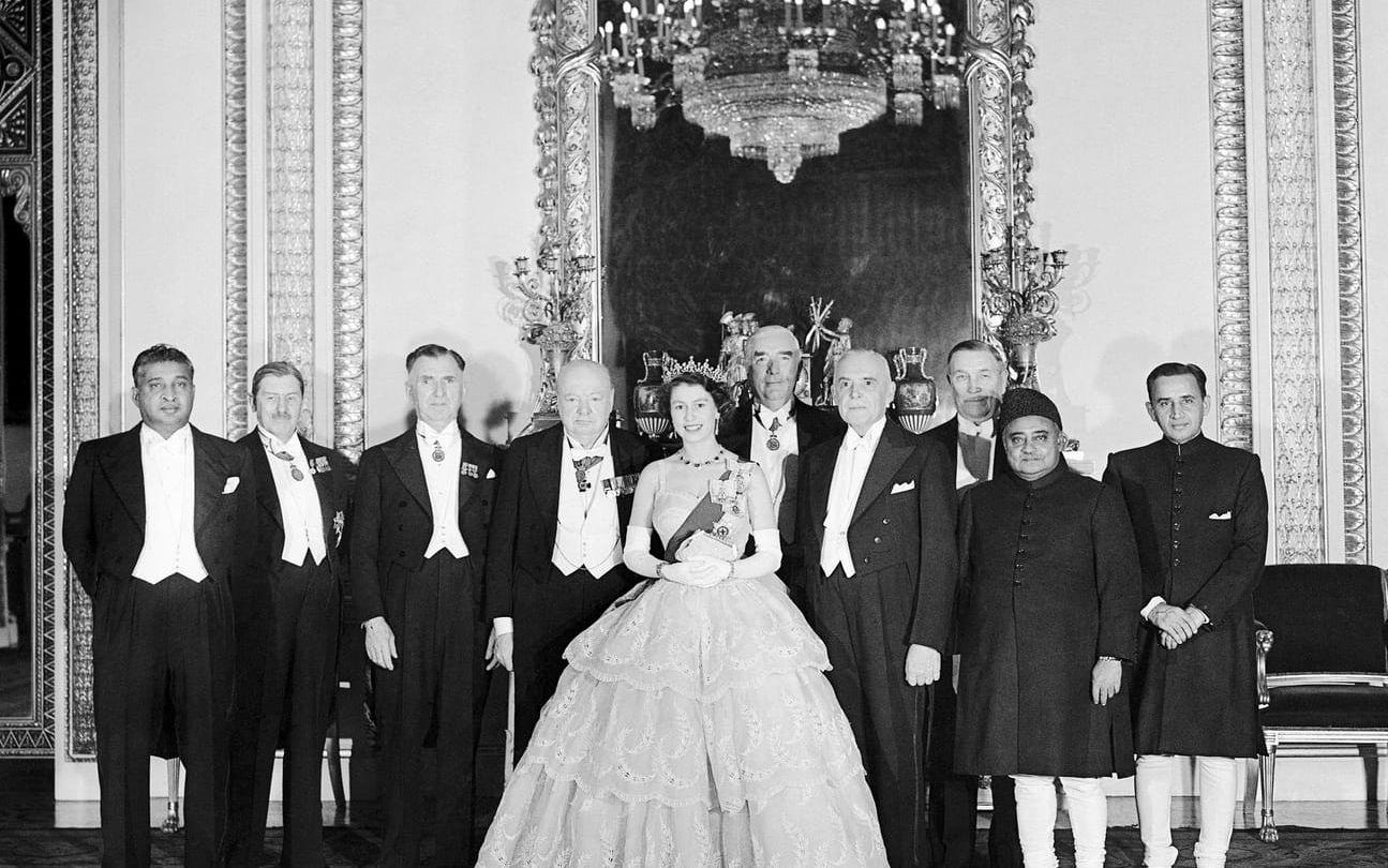 När Elizabeth blev drottning 1952 var Winston Churchill hennes första premiärminister. Här står de två bredvid varandra i tronrummet i Buckingham Palace tillsammans med övriga ledare i Samväldet.