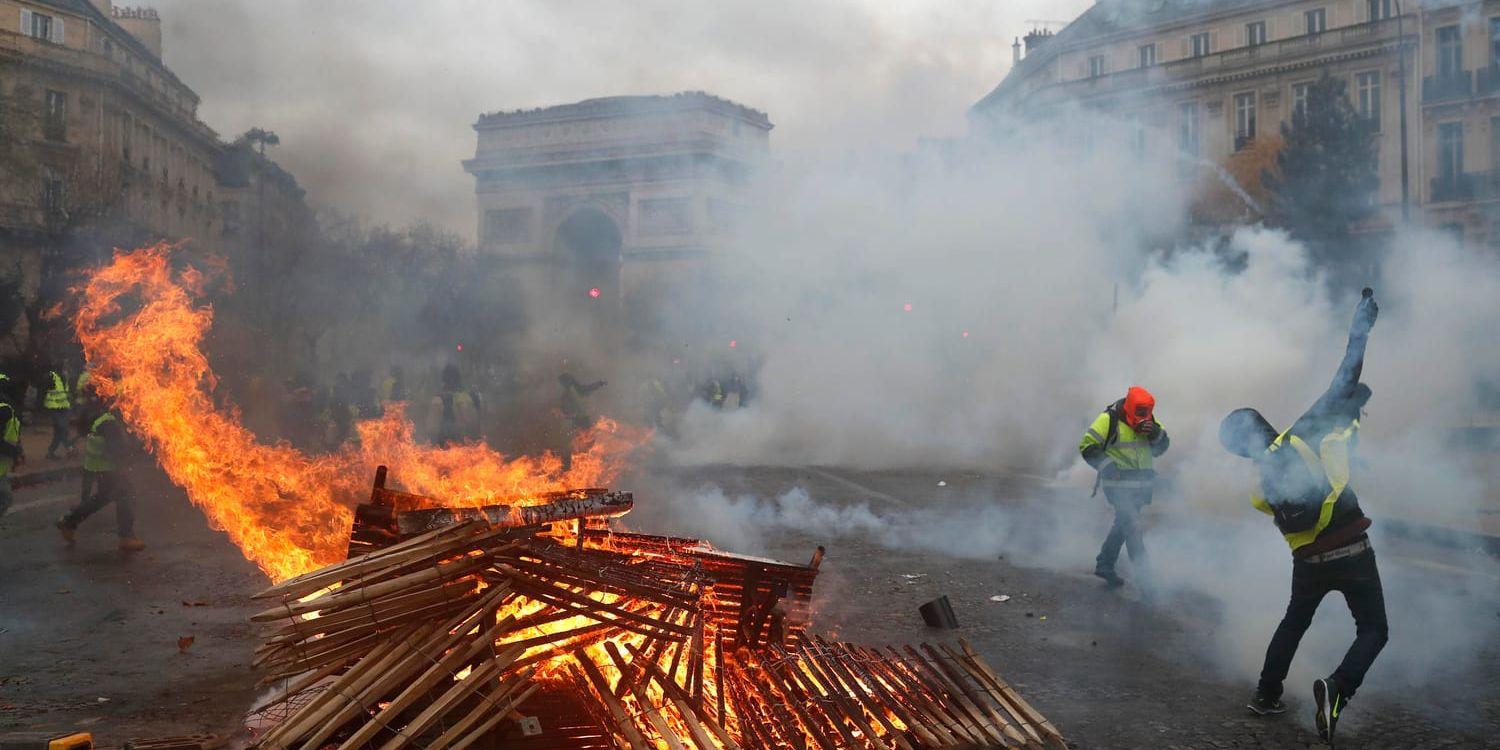 Demonstranter vid Triumfbågen i Paris i lördags. Franska myndigheter väntar nya protester under helgen.