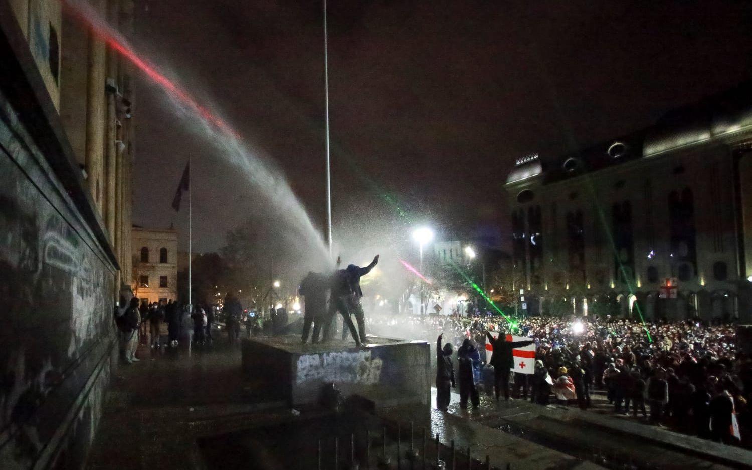 Vattenkanoner används mot demonstranterna utanför parlamentsbyggnaden i Tbilisi.