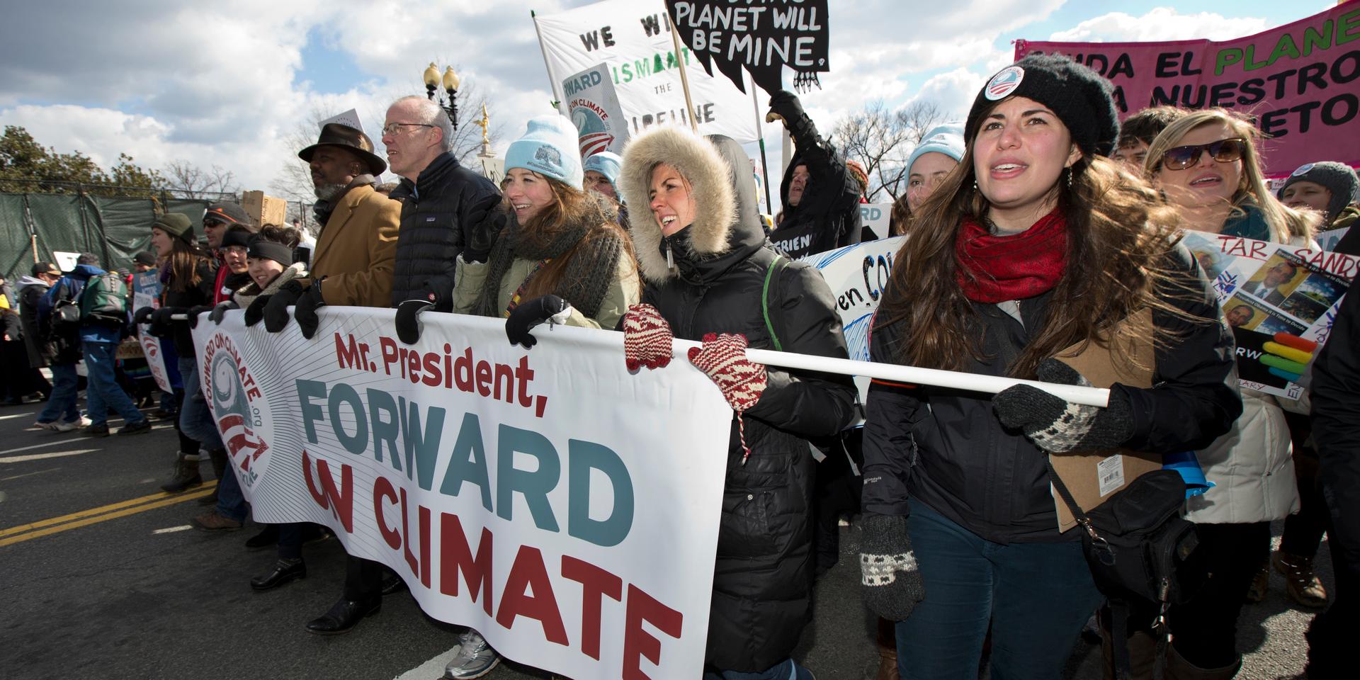 I centrum för miljödemonstrationen går Bill McKibben. Till höger om honom meddemonstranterna Fiona McRaith, Leah Qusba och Maayan Cohen. Bilden är tagen vid en marsch till Vita huset då Barack Obama var president.