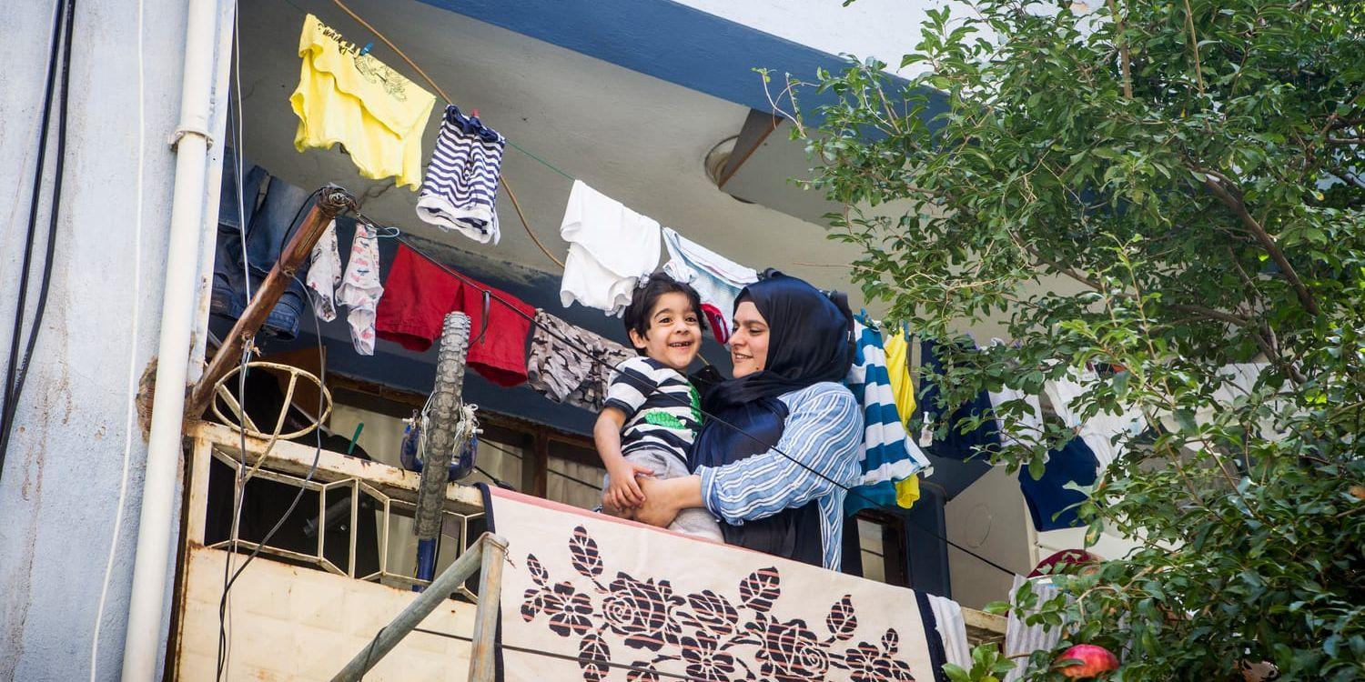 Razen med sonen Adil skattar bland tvätt på balkongen i Izmir. Det bor här tillsammans med pappa Milad och ytterligare två syskon.