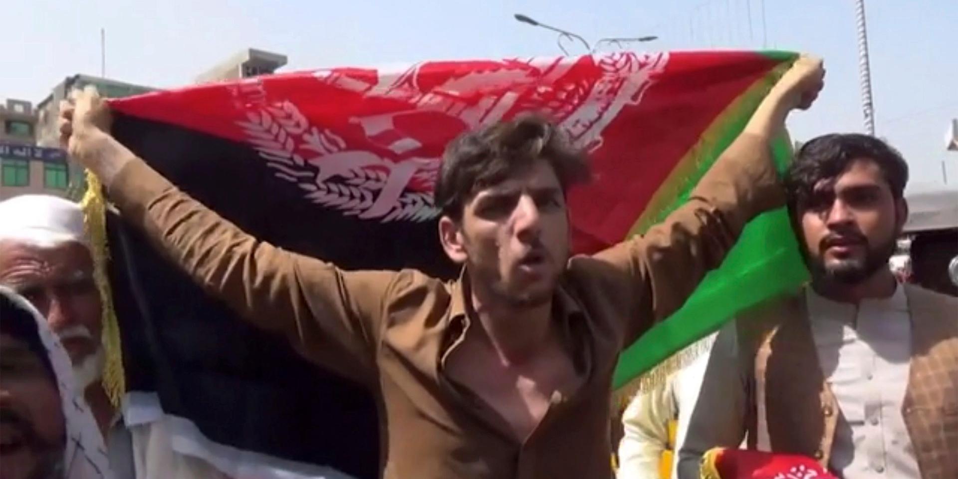 En man håller ut en flagga under protesterna mot talibanernas i Jalalabad på onsdagen. Minst tre människor dog vid skottlossningen, enligt obekräftad uppgift.