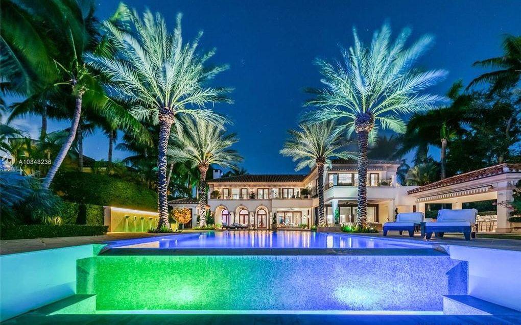 På kvällen lyser blå och gröna lampor upp både pool och palmer.