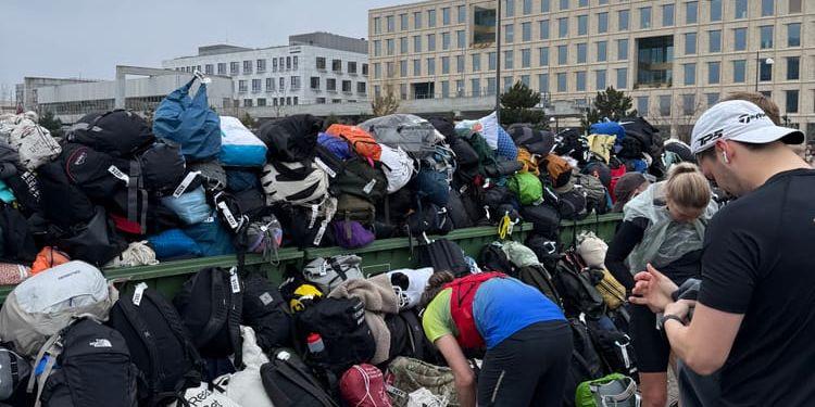 Folk försöker hitta sina väskor i den hög som lämnades.