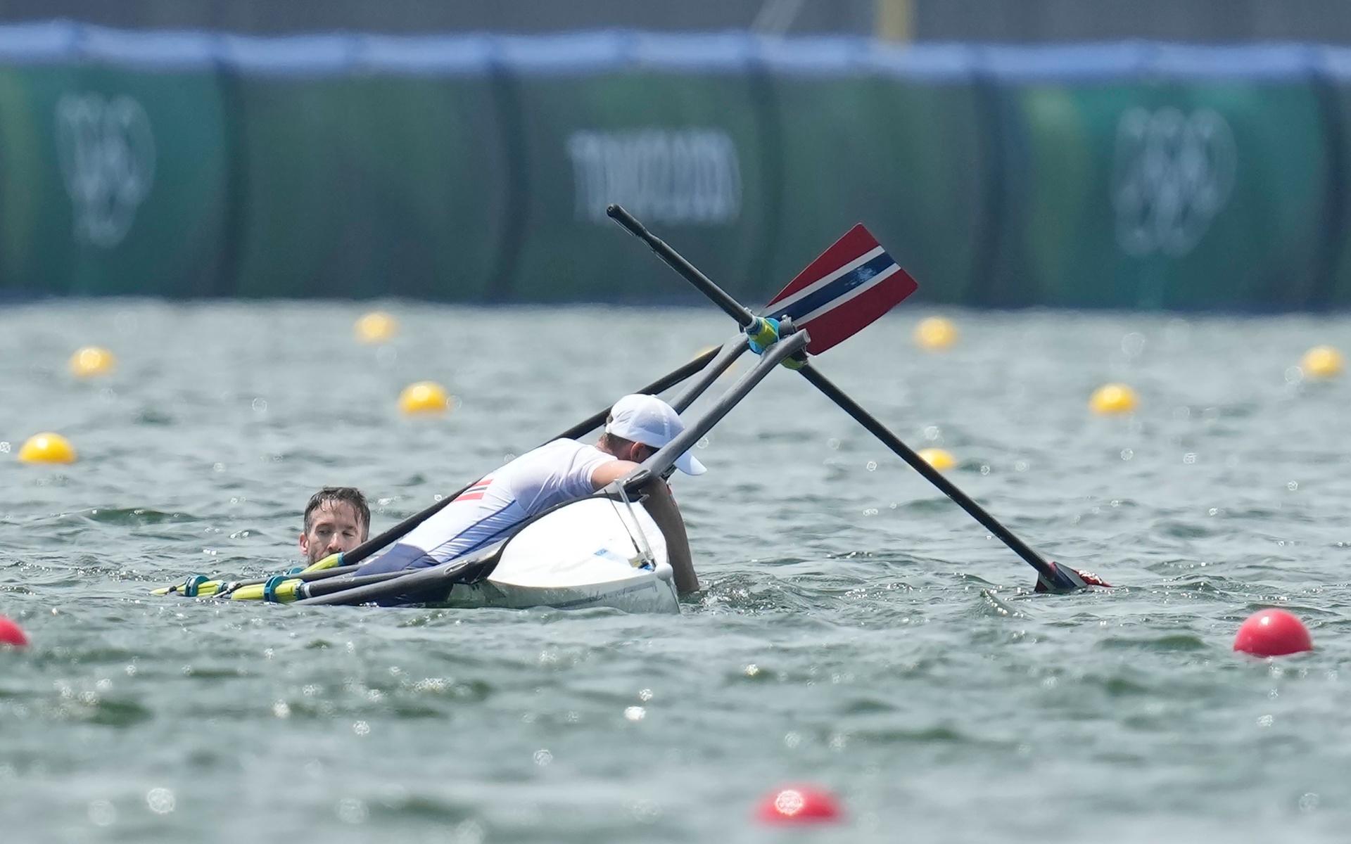 Kristoffer Brun and Are Weierholt Strandli of Norway hold on a boat after capsizing in the lightweight men&apos;s rowing double sculls semifinal at the 2020 Summer Olympics, Wednesday, July 28, 2021, in Tokyo, Japan. (AP Photo/Lee Jin-man)  OLYJM150