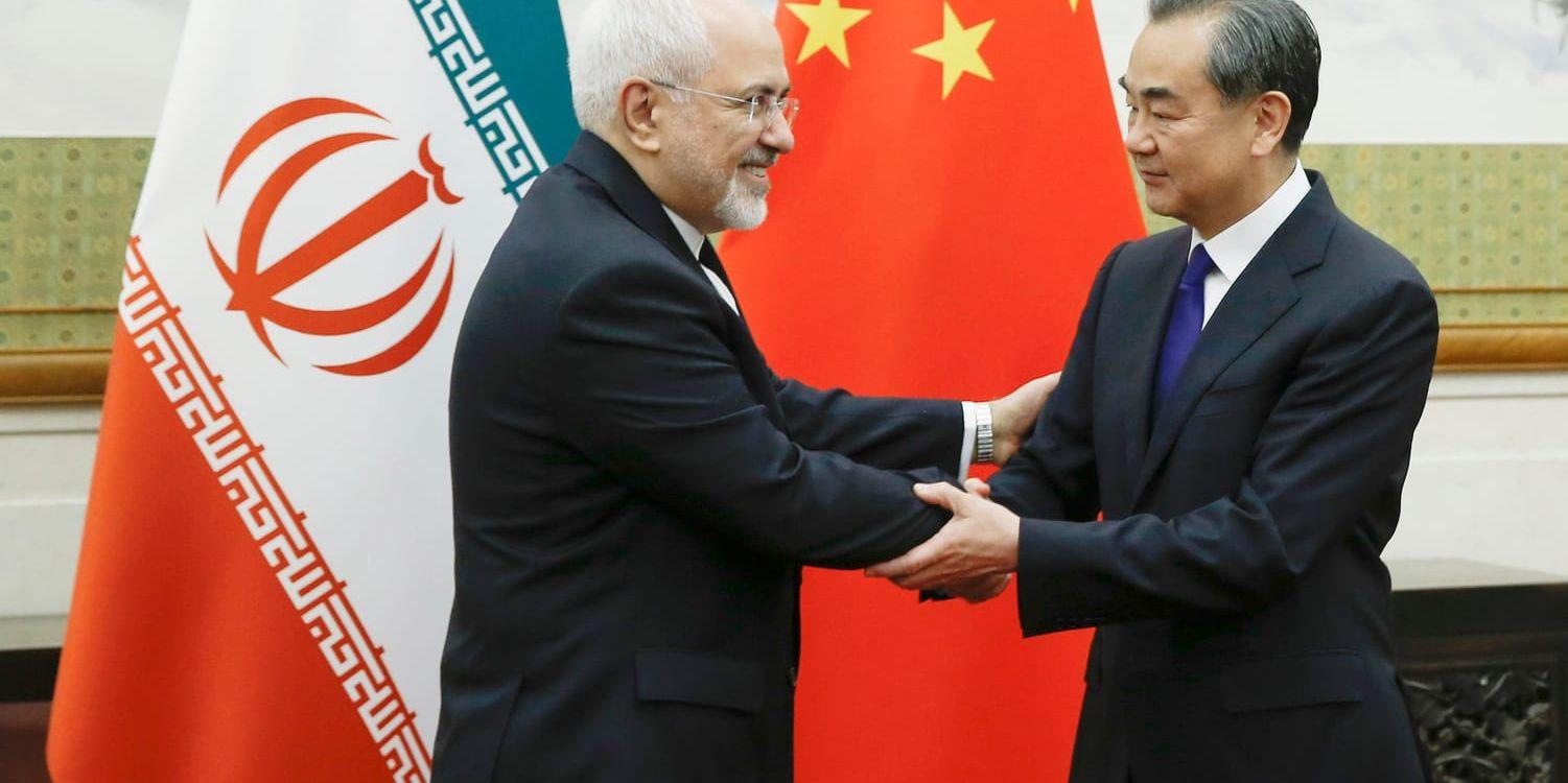 Irans utrikesminister Mohammad Javad Zarif (till vänster) hälsar på sin kinesiske kollega Wang Yi i Peking.