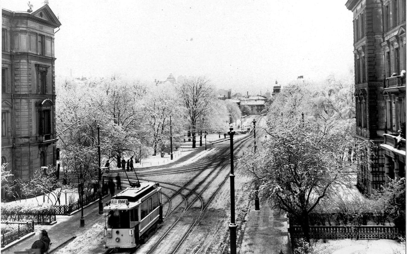 En spårvagn tar sig igenom snön på Viktoriagatan, norrut en snöig vinterdag. Vid spåren möter den en häst och vagn. I fonden Magasinsgatan. Bilden är tagen på 1910-talet.