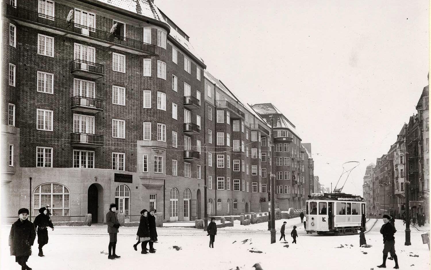 Barn och spårvagn högst upp på Aschebergsgatan en snöig dag runt 1915. Huset står där än i dag.