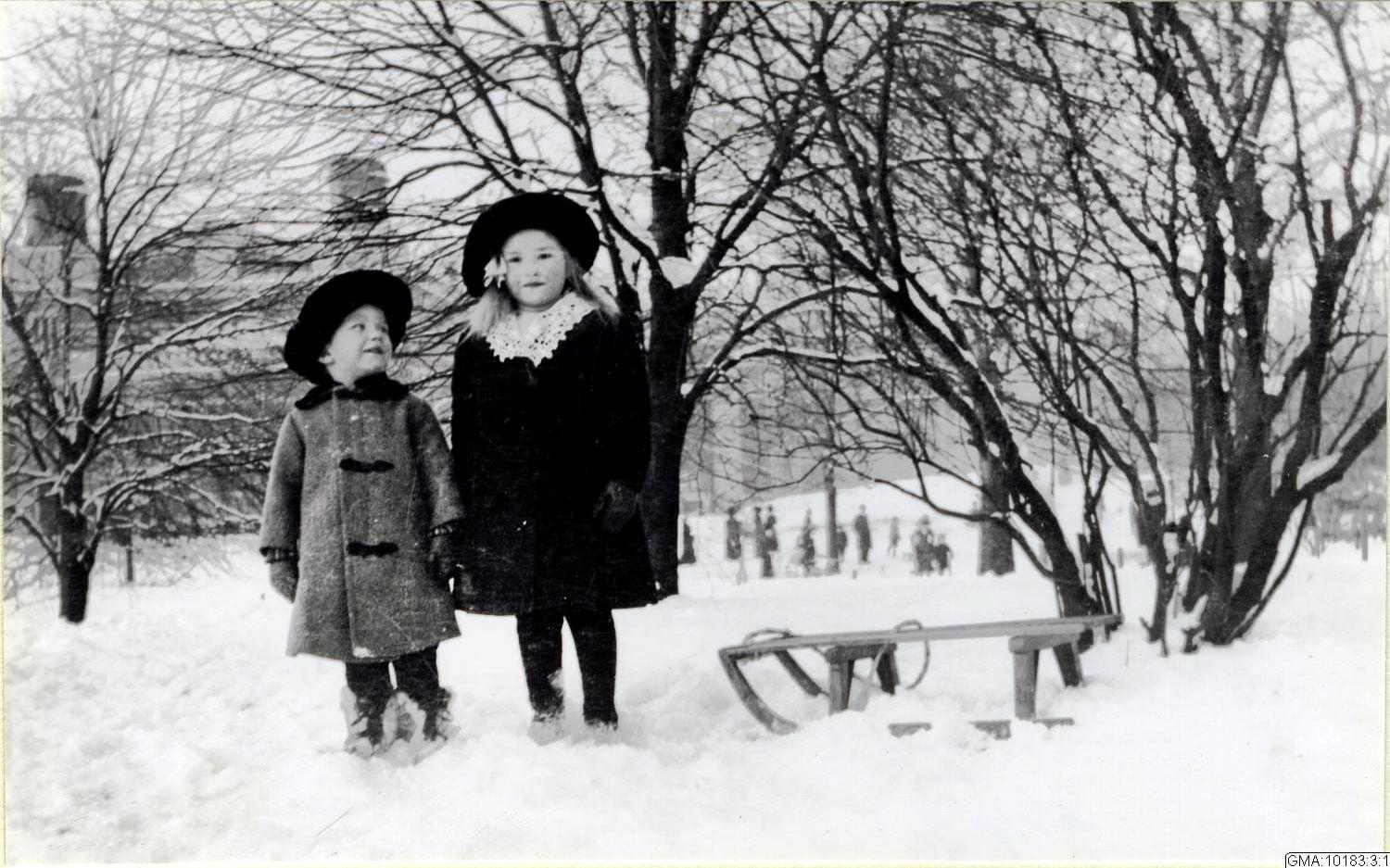 Två finklädda små barn vid Vasaparkens kälkbacke vintern 1914.