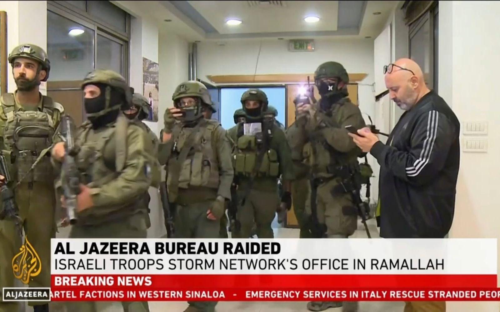 Bild ur Al Jazeeras direktsändning som visar israeliska soldater i tv-bolagets lokaler.