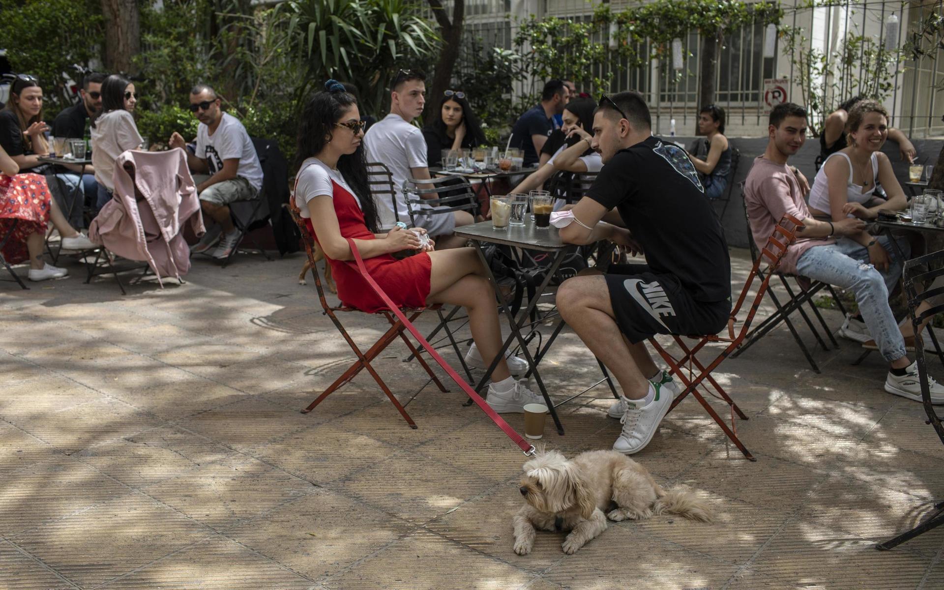 Människor hänger på ett kafé i Aten efter att Grekland börjat tillåta sittande gäster för första gången på ett halvår. Nu hoppas landet att turisterna återvänder till sommaren.