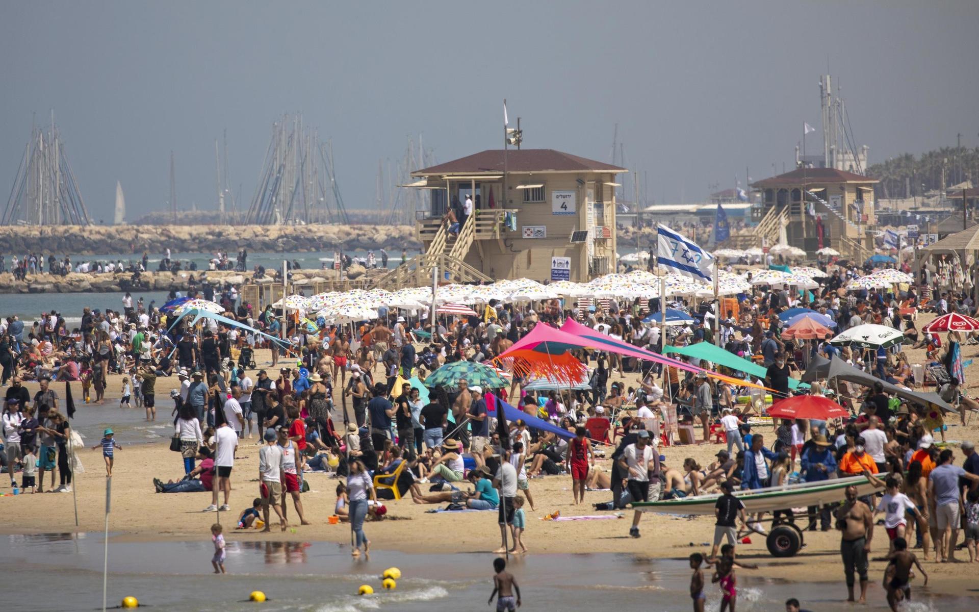 Människor flockas på en strand i Israel. Landets vaccinationskampanj anses vara en av världens mest framgångsrika.