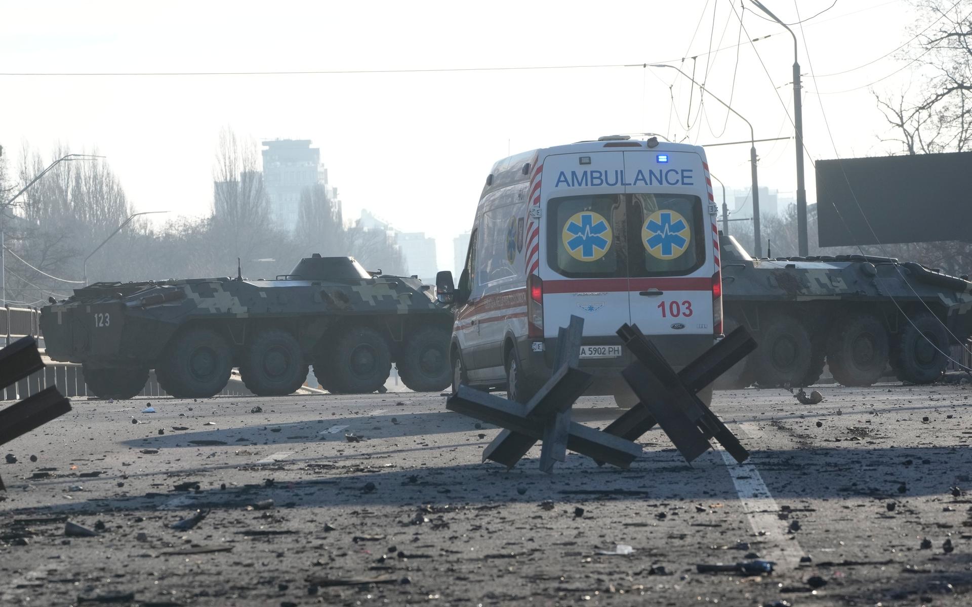 Ambulans parkerad nära barrikader och ukrainska pansarfordon på en gata i Kiev. Intensiva strider har pågått i staden under lördagsmorgonen.