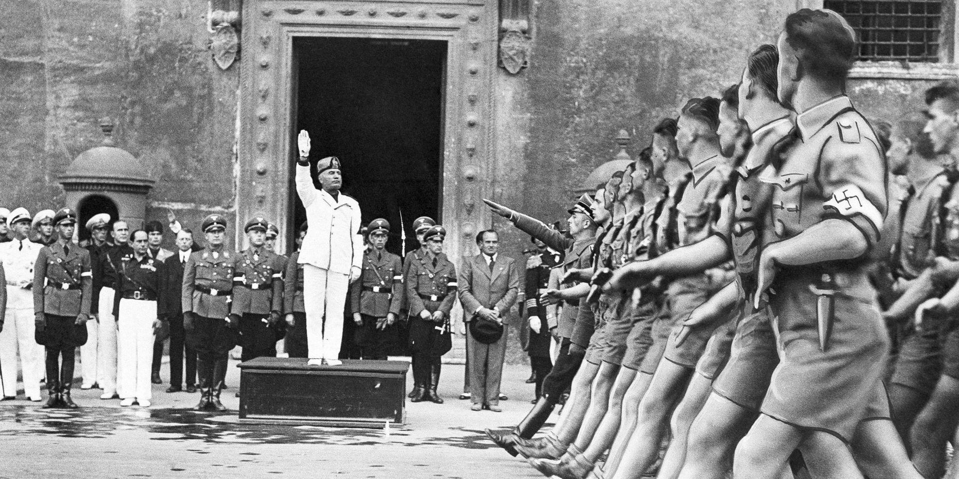 Den italienska fascistledaren Benito Mussolini lyfter sin hand i den fascistiska hälsningen medan medlemmar ur nazistiska Hitlerjugend parraderar förbi under ett besök i Rom i oktober 1936. 