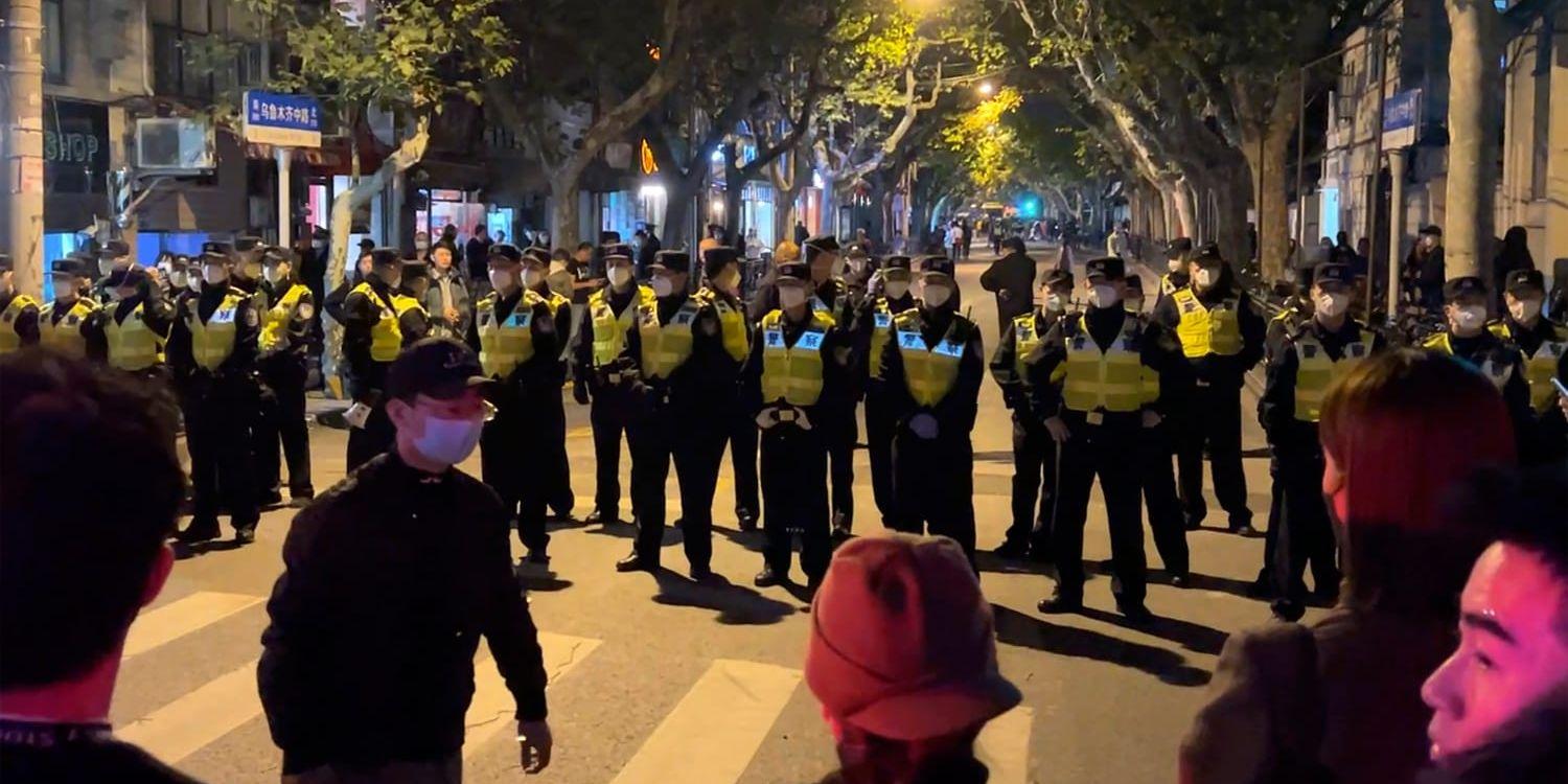 Kinesisk polis spärrar av en gata där demonstranter har samlats i Shangha, 27 november. I flera kinesiska städer har protester mot de hårda vocidrestriktionerna rasat den senaste tiden.