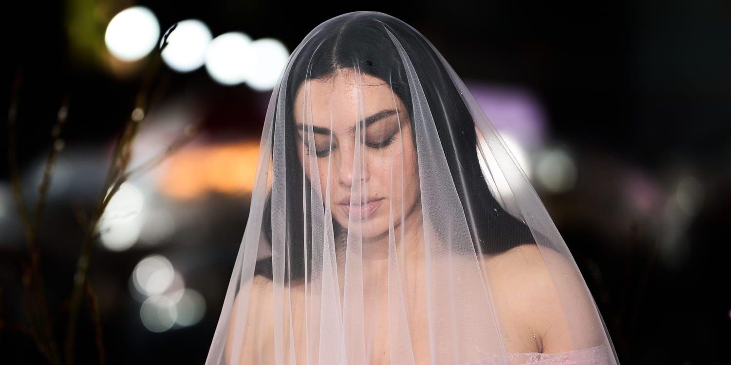 Kvinna med rosa slöja