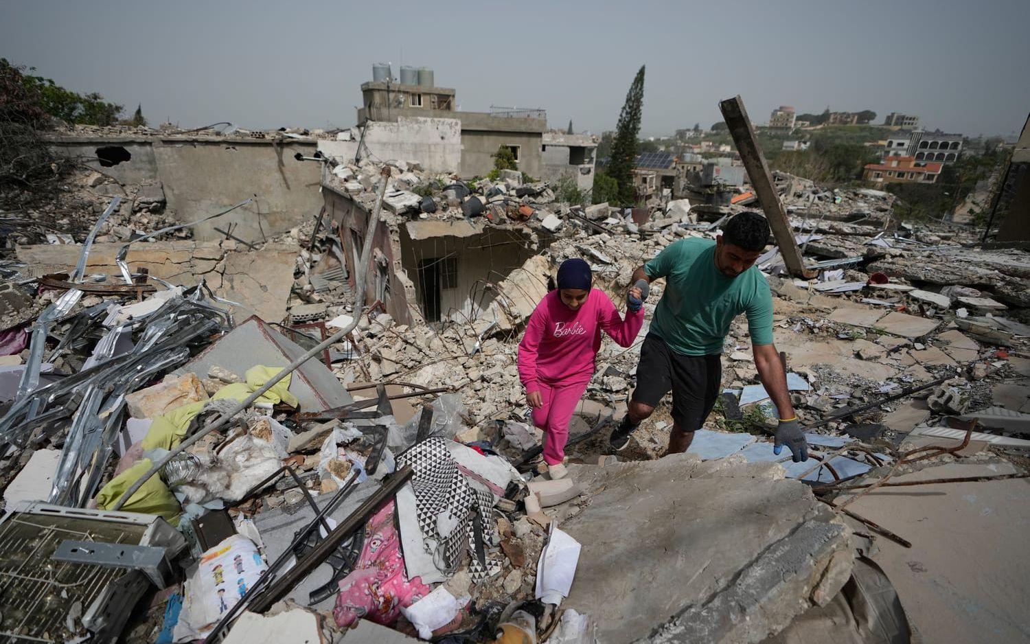 Boende går på spillrorna av förstörda hus i byn Jibchit under den andra dagen av den sköra vapenvilan mellan Hizbollah och Israel.