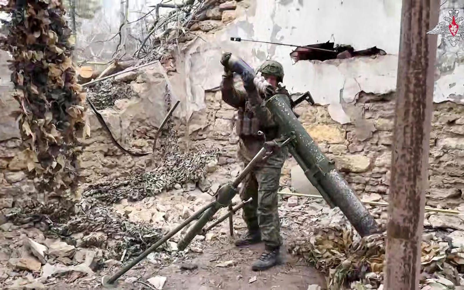 Den här bilden som har sänts ut av ryska myndigheter sägs visa en rysk soldat som laddar en artilleripjäs vid fronten någonstans i Ukraina.