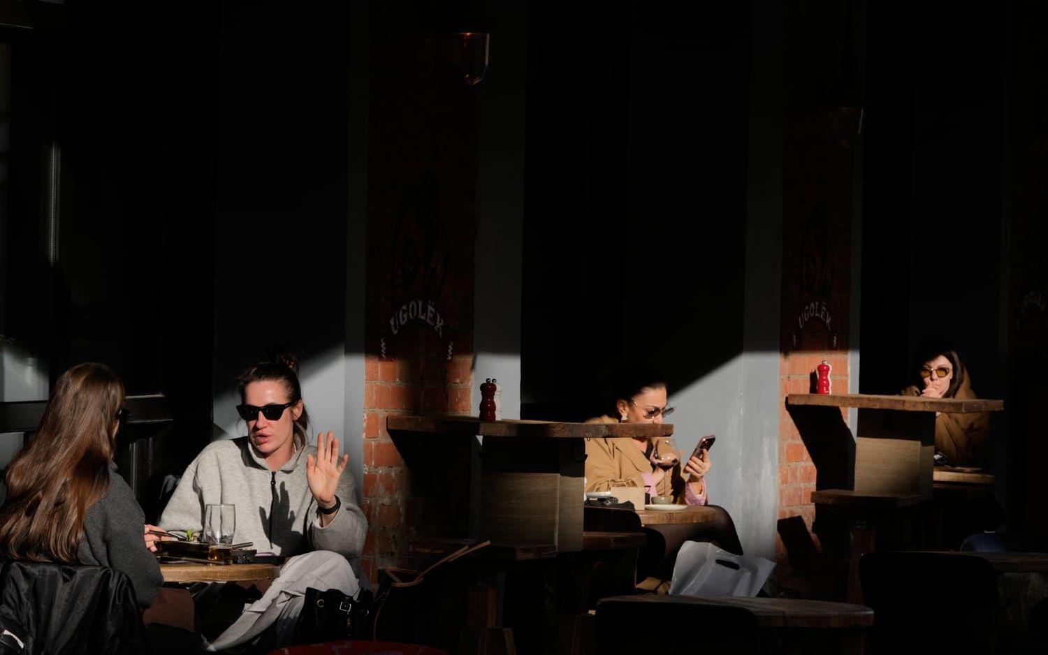 Människor på en uteservering i solen i Moskva den 13 april.