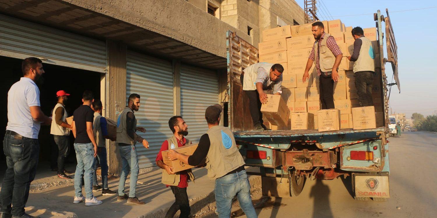 Nödproviant från FN:s livsmedelsprogram WFP till människor som flytt striderna i nordöstra Syrien lastas av i staden al-Hasakah under tisdagen. 