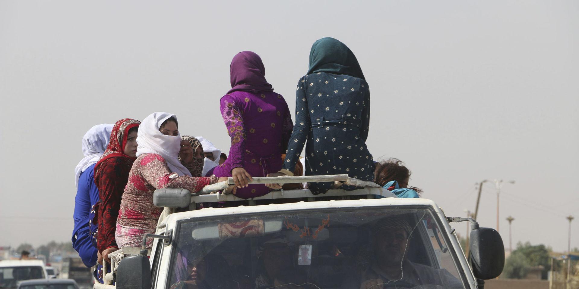 Kvinnor färdas längs en väg i närheten av al-Hasakah, omkring 10 mil söder om gränsen mot Turkiet, i fredags. 