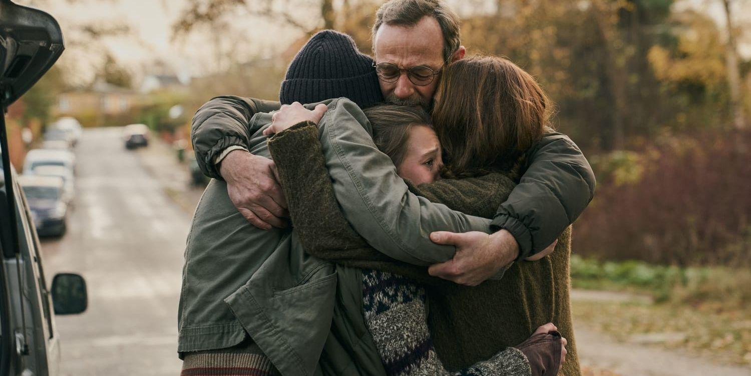 En familj drabbad av sorg kramar om varandra.