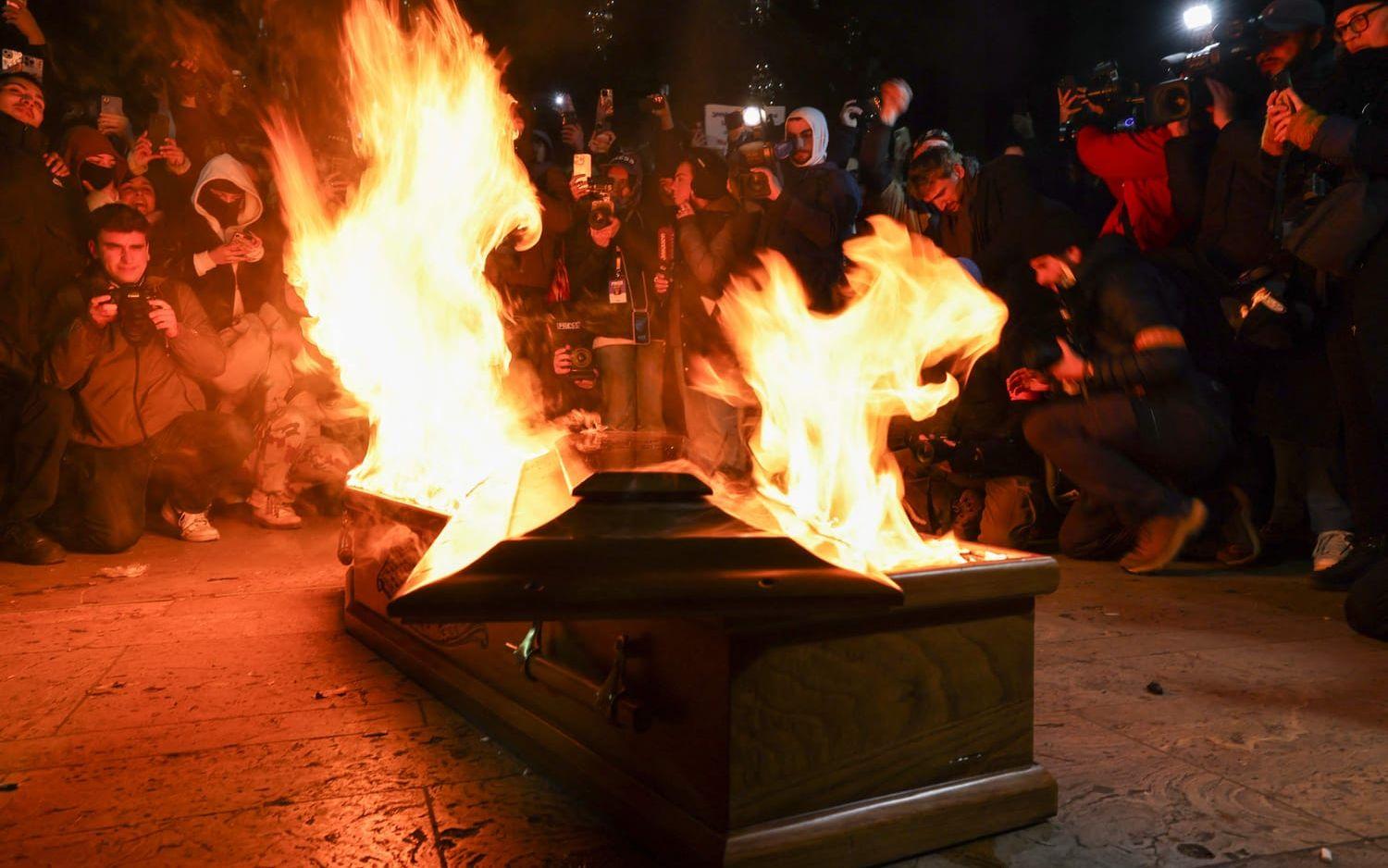 En kista med en bild på miljardären och regeringspartiet Georgisk dröms grundare, Bidzina Ivanisjvili, brinner under demonstrationen.